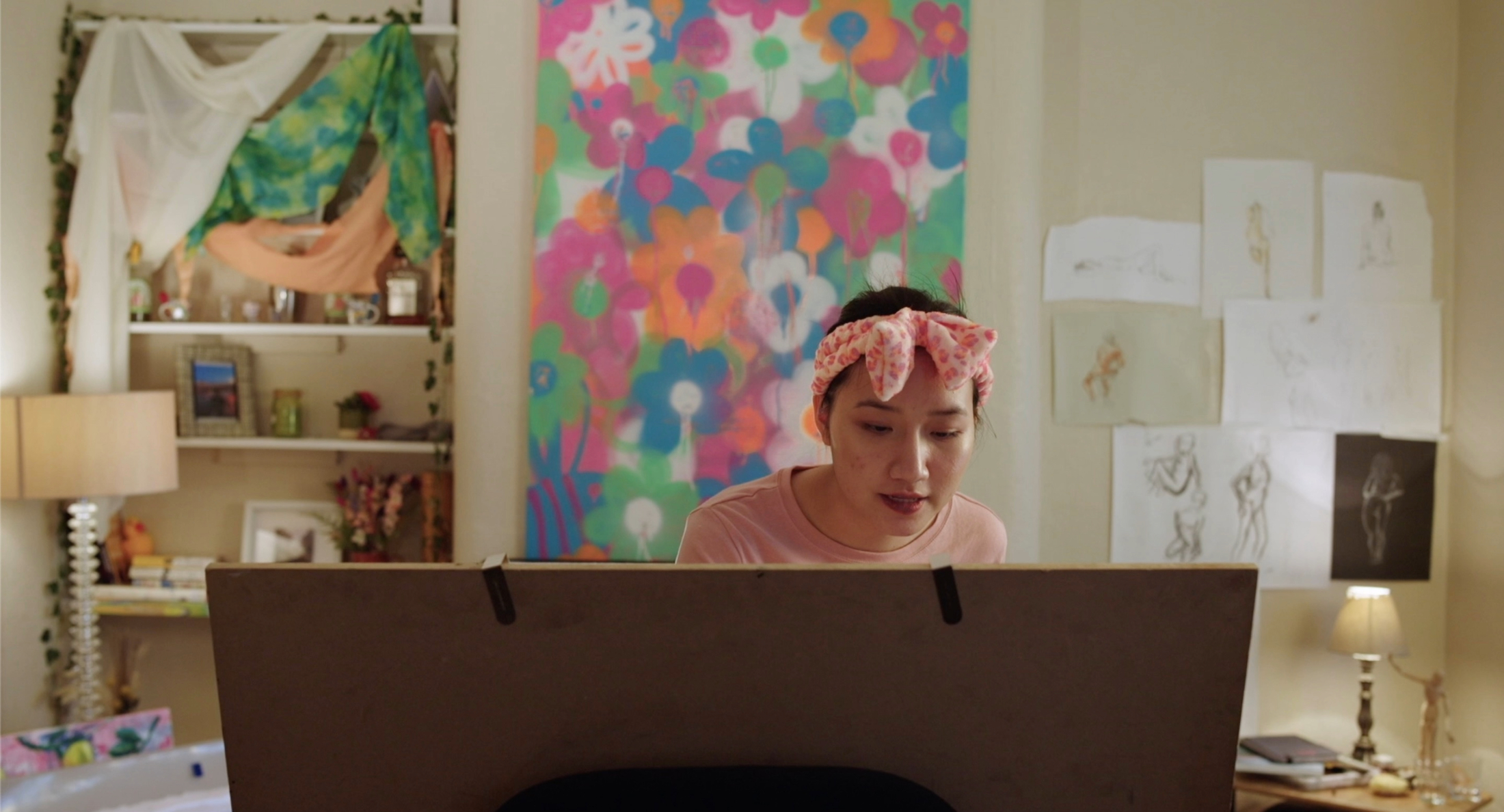 Woman working on a painting canvas in front of her