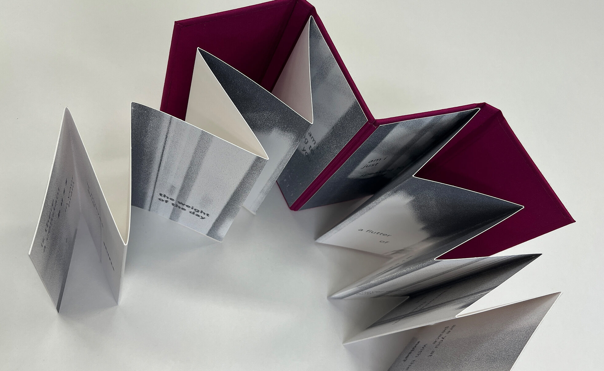 double accordion artist book in burgundy cloth with screenprinted pages