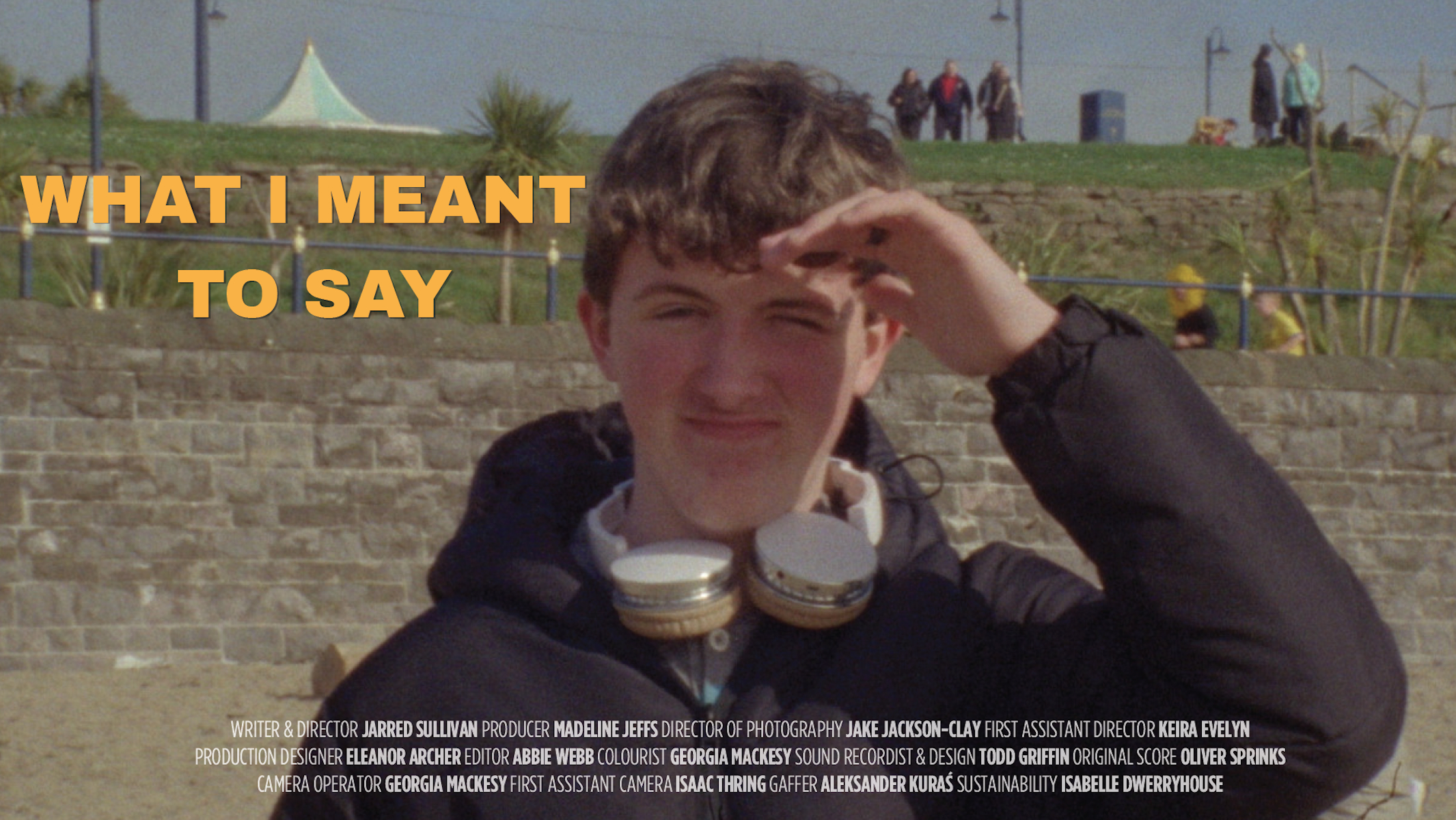 Thumbnail for What I Meant to Say Press Kit, showing Aaron squinting in the sun on Barry Island beach.